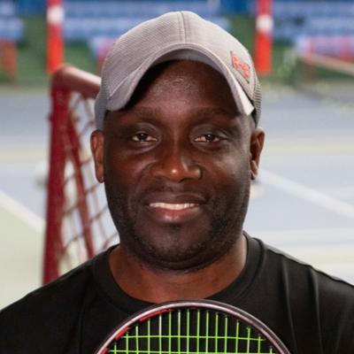 John Fumi close-up photo with a tennis court in background