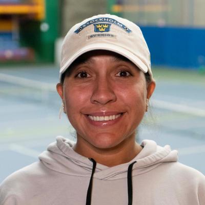 Patricia Zapata close-up photo with a tennis court in background