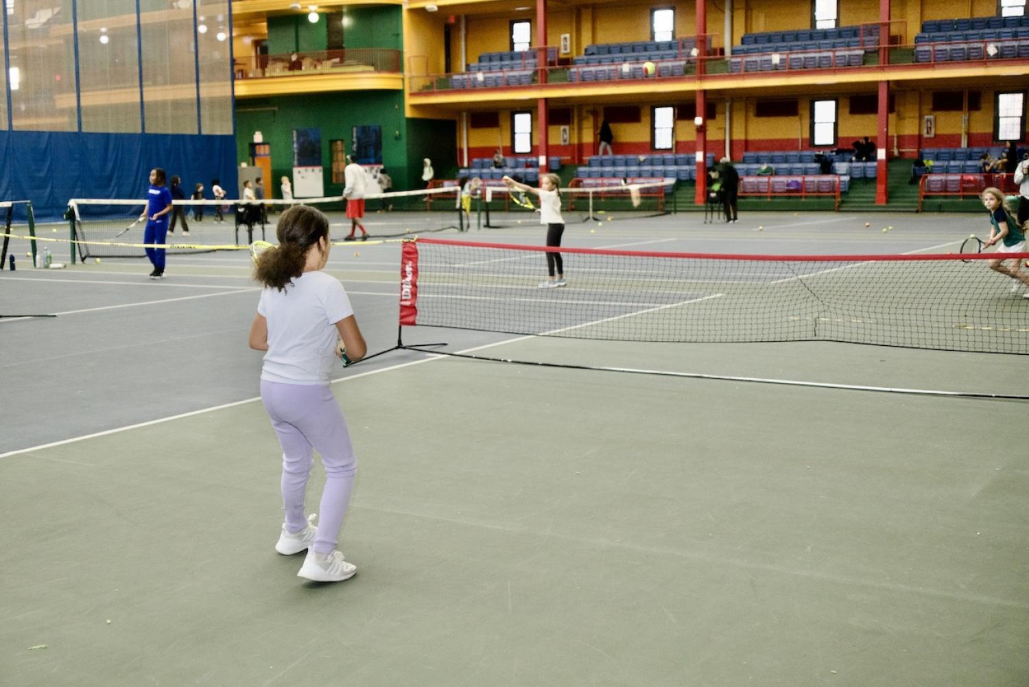 Youth playing tennis matches.